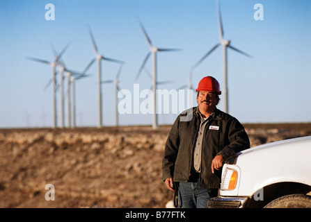 Worker leaning against truck wind turbines background Stock Photo