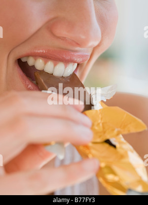Close up of woman biting chocolate bar Stock Photo