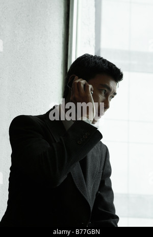 Businessman using cell phone in office Stock Photo