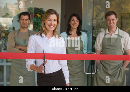 Small business owner cutting red ribbon grand opening Stock Photo