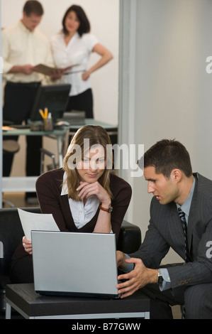 Businessman and businesswoman using laptop Stock Photo