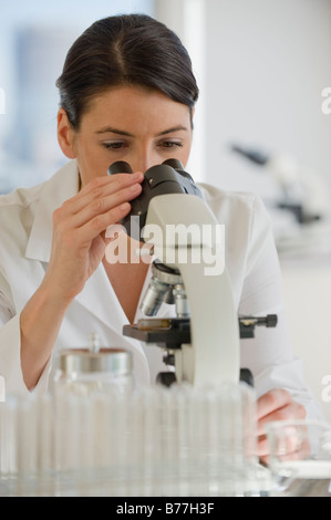 Scientist using microscope pharmaceutical laboratory Stock Photo