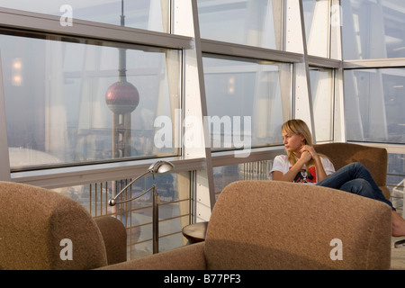 Young woman looking out of the window, Shanghai, China, Asia Stock Photo