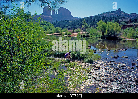 Woman kneeling at Oak Creek in Red Rock State Park Sedona Arizona Stock Photo