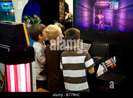 Boys playing a video game in an arcade Stock Photo