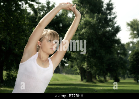Young, dark blond woman stretching Stock Photo