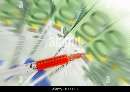 Syringe over 100 Euro banknotes, symbolic for a cash injection Stock Photo