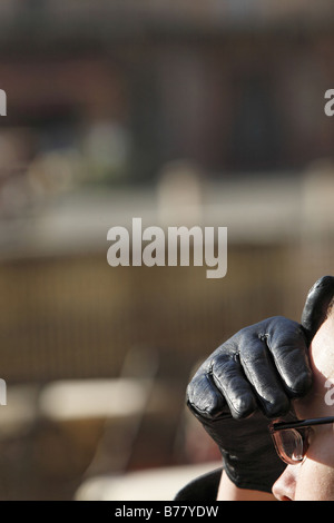Woman Wearing Black Gloves Protecting Her Eyes from the Sun Stock Photo
