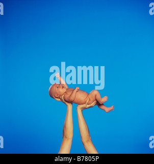 A baby being held aloft Stock Photo