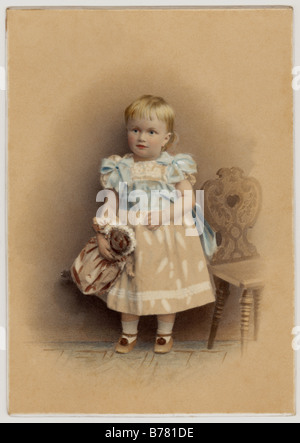 Original tinted portrait of cute Victorian child (girl or boy as they were dressed the same in these times) holding a doll, circa 1880's, U.K. Stock Photo