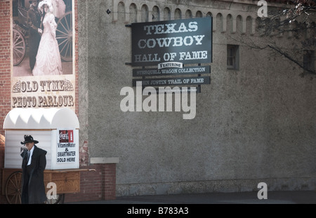 a cowboy walking by the famous Texas Cowboy Hall of Fame in the Historic Stockyards of Fort Worth Texas Stock Photo