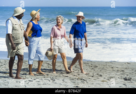 Seniors relaxing together, walking on beach, Miami Stock Photo