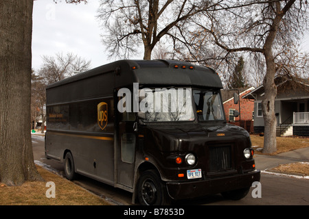 Brown classic UPS truck parked on residential neighborhood side street in winter. Stock Photo