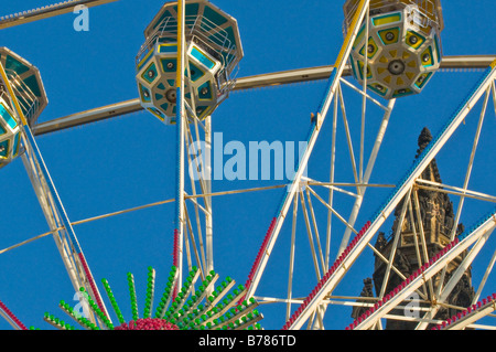 Big wheel with the Scott Monument in the background, at the Christmas Fair, Edinburgh, Scotland. Stock Photo