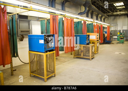 Wide angle view of the metal workshop area of a technical trade school with welding torch machines at the work stations Stock Photo