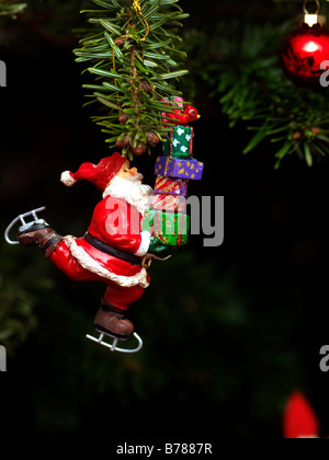 Father Christmas Figure Carrying Presents on a Christmas Tree Stock Photo