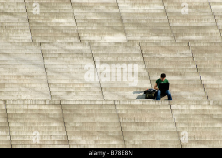 Man sitting alone on flight of stairs while working on a laptop, Berlin, Germany, Europe Stock Photo