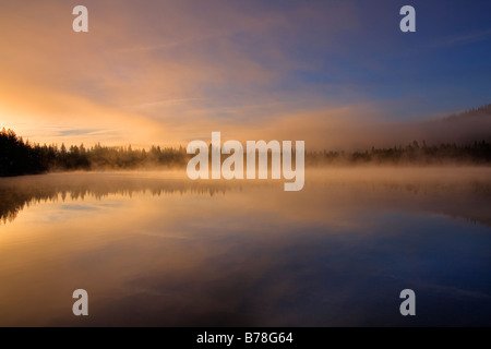 Mist,reflections and alpenglow on Donner Lake,California at sunrise Stock Photo