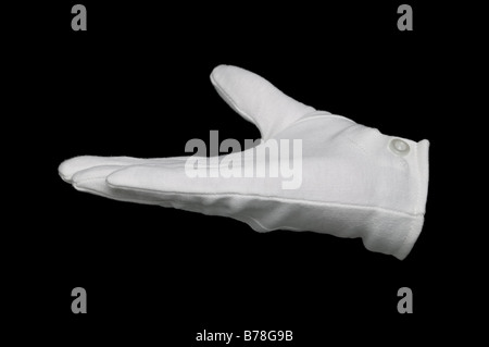 Hand in a white glove held out flat isolated on a black background Good for product placement Stock Photo