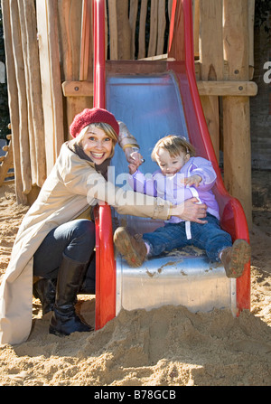 Mother and her 2-year-old daughter on a slide, playground, Zurich, Switzerland, Europe Stock Photo