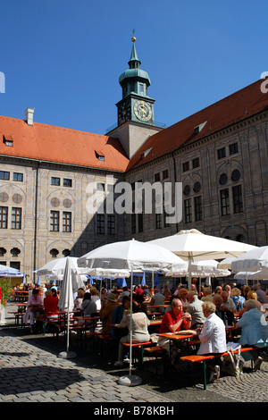 Terrace of a wine tavern in the inner yard of the Residence, in the back a clock tower, Residenzstrasse street, historic city c Stock Photo