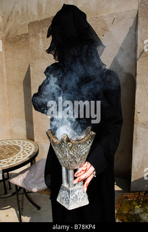 Woman with henna-painting holding incense holder in her hands, Dubai, United Arab Emirates, Middle East Stock Photo