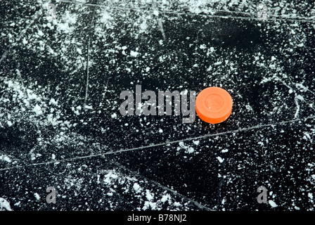 Ice hockey puck on frozen water surface, elevated view Stock Photo