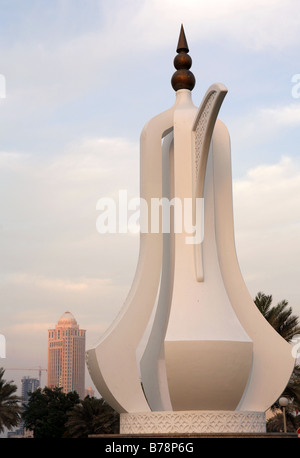 The coffeepot (dallah) monument on the Corniche in Doha,Qatar,with the Four Seasons Hotel out of focus behind it. Stock Photo