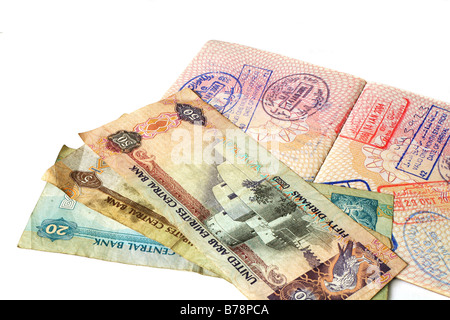 A passport with visa stamps for the United Arab Emirates and some of the state's currency notes. Stock Photo