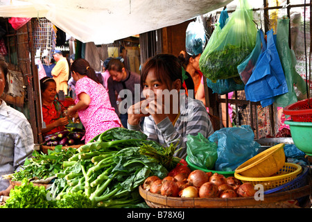 Cambodian girl selling vegetables on her stall at Central Market (Psar Thmei) in Phnom Penh, Cambodia Stock Photo
