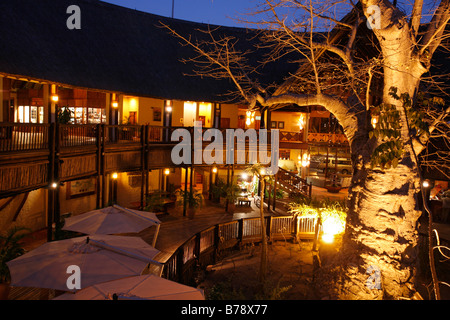 The Mowana Lodge on the Chobe at dusk with a large baobab tree as a centrepiece around which the reception area is built Stock Photo