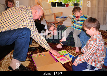 Family Group playing board game Ludo Home Stock Photo
