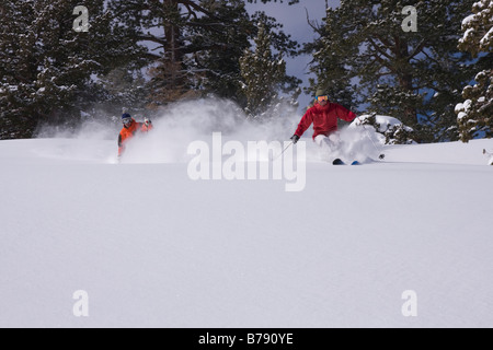 A man and woman skiing powder snow at Northstar at Tahoe ski area near Lake Tahoe in California Stock Photo