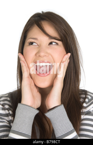 A young woman holds her hands on her cheeks in surprise Stock Photo