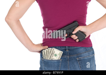 A woman stands ready to protect her cash with a gun Stock Photo