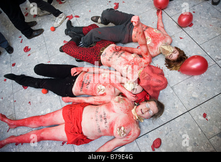 A group of female campaigners wearing red body-paint at 'flash mob' protest inside Heathrow airport Terminal Five Stock Photo
