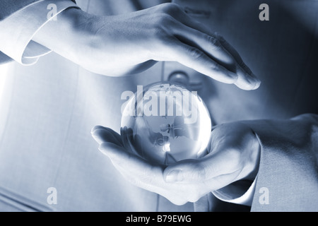 businessman holding mini globe Stock Photo