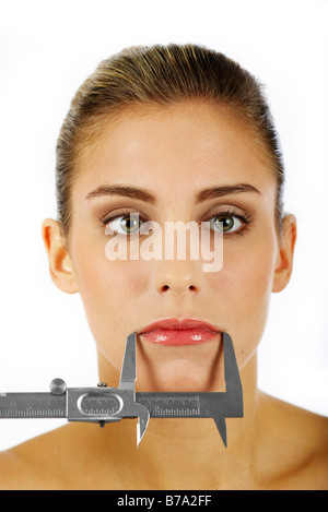 Woman's mouth being measured with a caliper rule Stock Photo