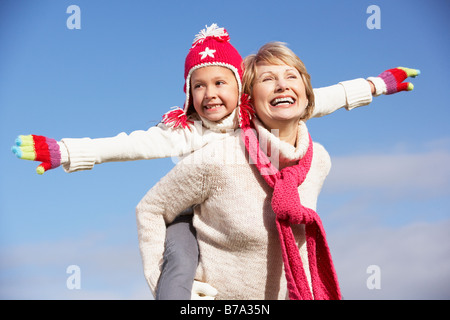 Grandmother Giving Her Granddaughter A Piggy Back Ride Stock Photo