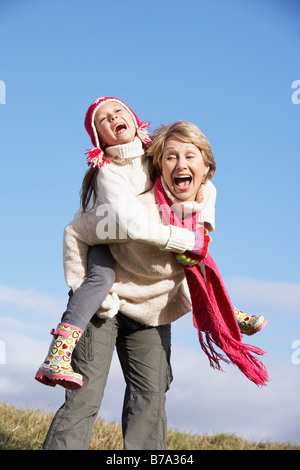 Grandmother Giving Her Granddaughter A Piggy Back Ride Stock Photo