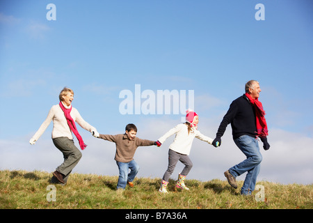 Grandparents And Grandchildren Running In The Park Stock Photo