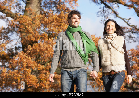 Young Couple Walking In Park Holding Hands Stock Photo