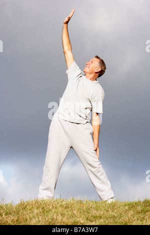 Senior Man Stretching In The Park Stock Photo