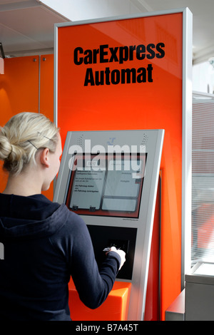 Woman using Car Express self service terminal of the Sixt AG car rental company in the Munich Airports, Bavaria, Germany, Europe Stock Photo