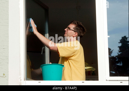 Young man cleaning windows Stock Photo