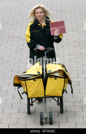 Mailwoman of the Deutsche Post AG, German post, pushing a cart filled with letters, delivering mail, Regensburg, Bavaria, Germa
