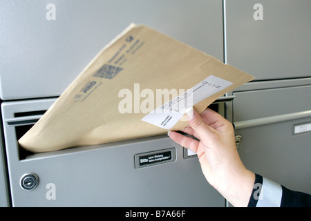 Hand of a mailwoman of the Deutsche Post AG, German post, delivering mail, Regensburg, Bavaria, Germany, Europe
