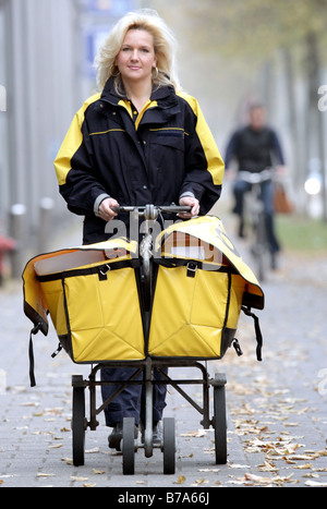 Mailwoman of the Deutsche Post AG, German post, pushing a cart filled with letters, Regensburg, Bavaria, Germany, Europe