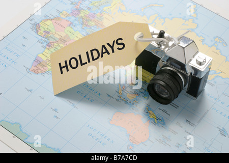 Camera on world map with 'Holidays' tag Stock Photo