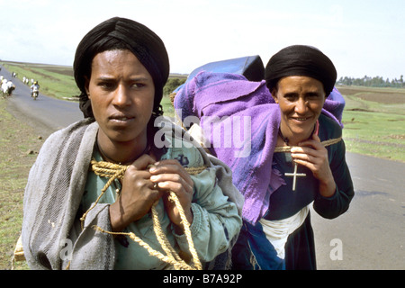 Ethiopian women carrying water canisters on their backs. Stock Photo